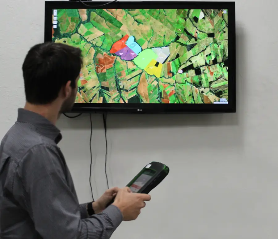 Gestor da fazenda acompanhando o mapa de pastos da JetBov com o leitor de brincos na mão